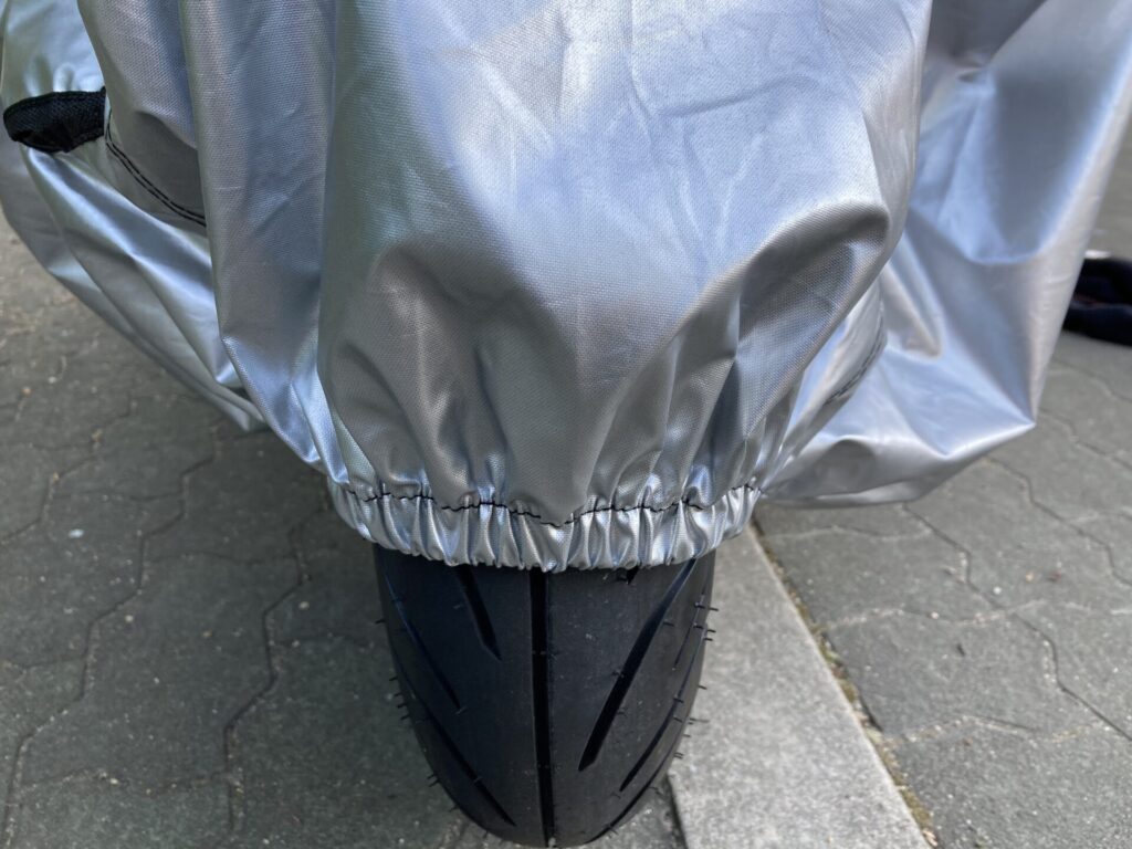 Barrichelloバイクカバー2LをPCX125の前輪に装着した状態。タイヤまでカバーされて地面スレスレのジャストサイズ