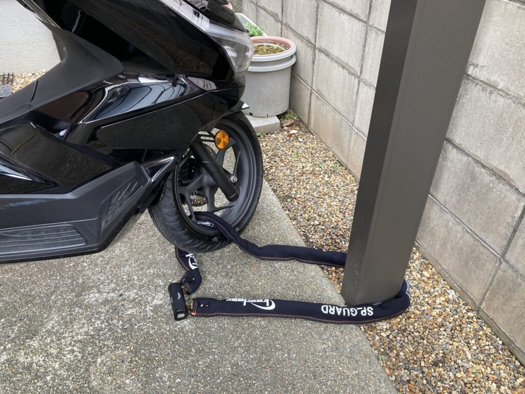 PCX125の前輪とカーポートの柱をKaedearチェーンロックで地球ロックした状態